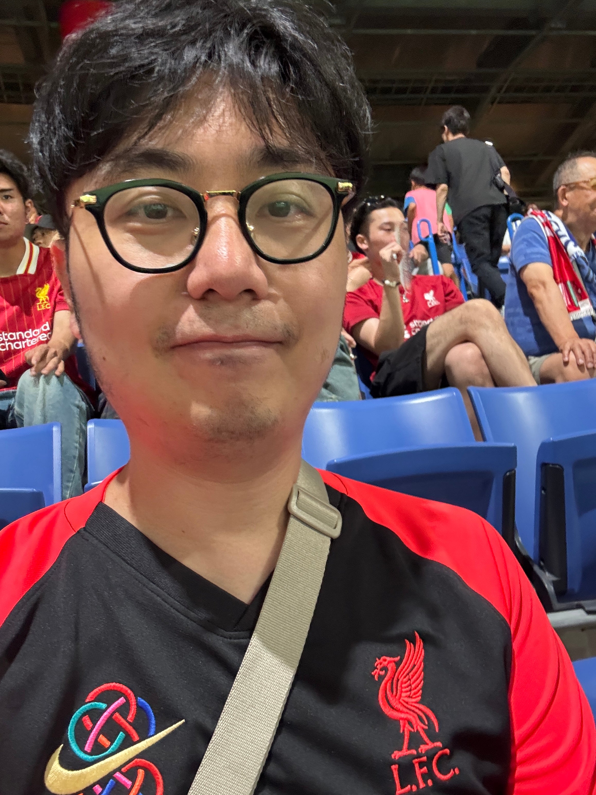 John Lu sitting in the stands at a stadium