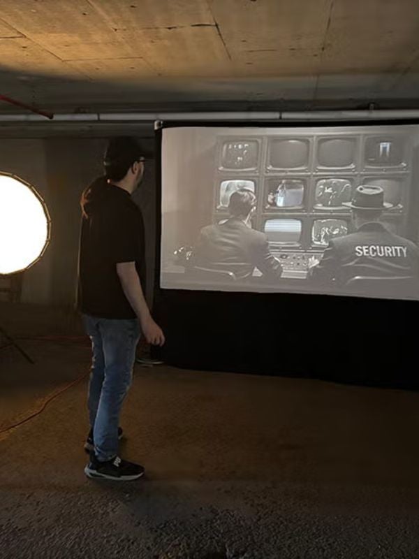 James Malzahn stands with his installation Harmony Through Obedience, a carefully staged AI Generated Protype of 1950s-style living room