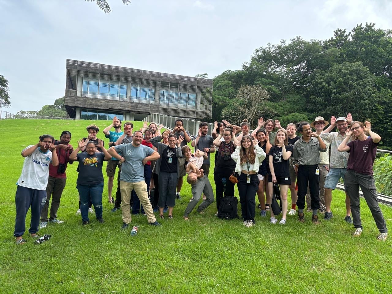 A group of people holding up hands to their heads like animal ears