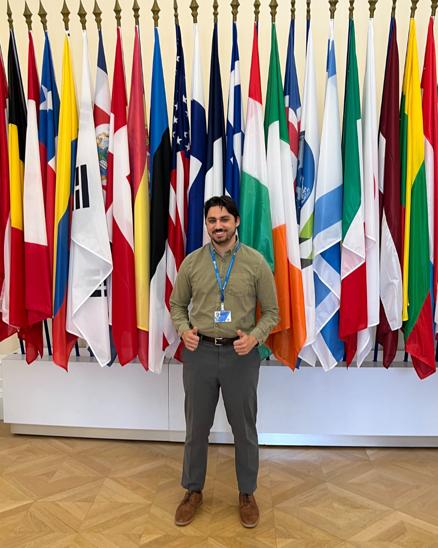 Timothy Crincoli in front of a wall of flags