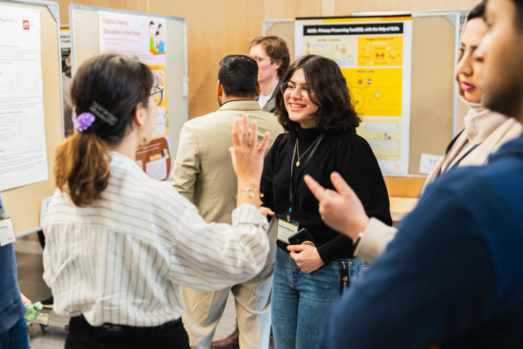 Students smiling and chatting about the research poster boards
