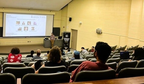 lecture with people watching a presenter and screen images