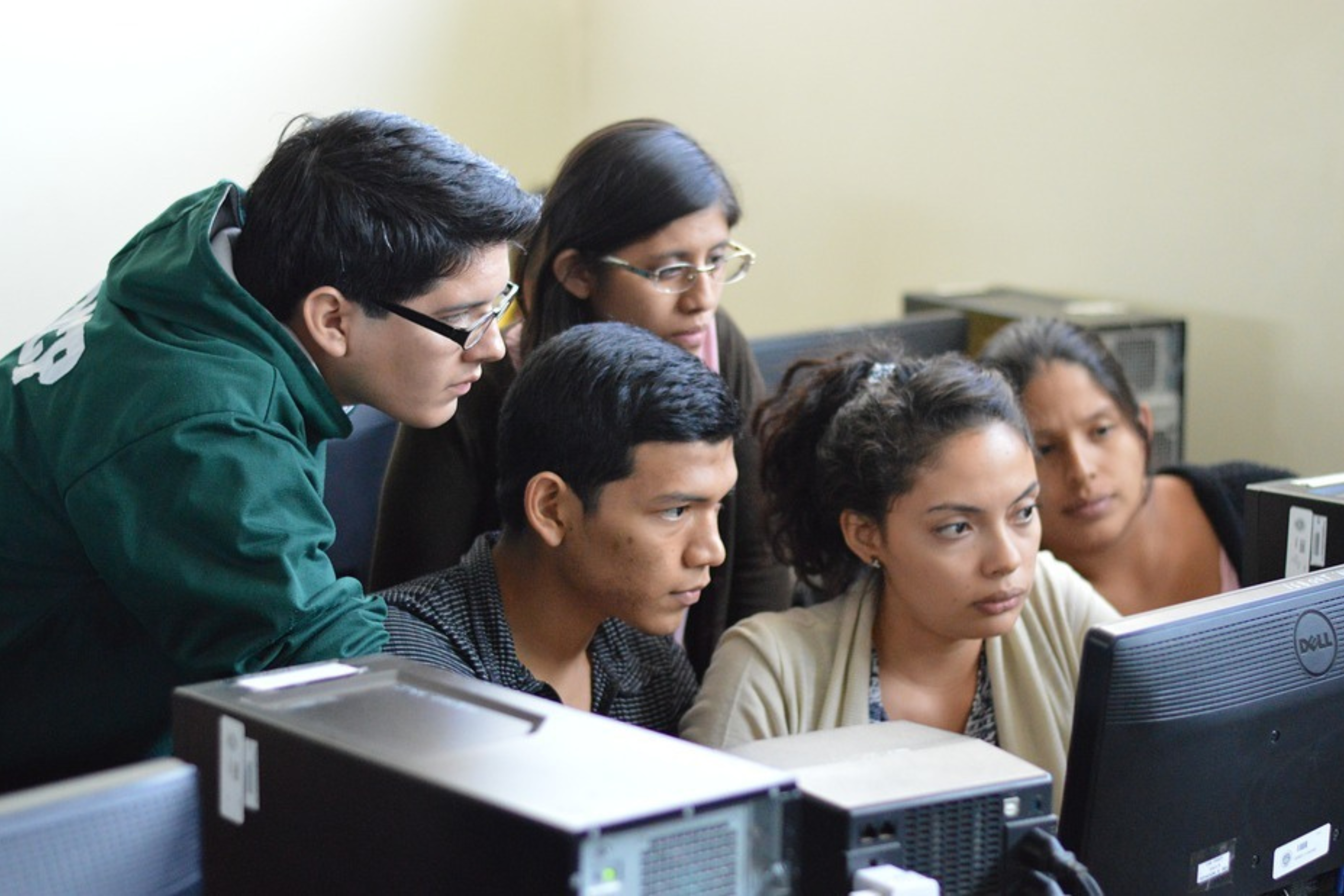 students grouped around looking at a laptop