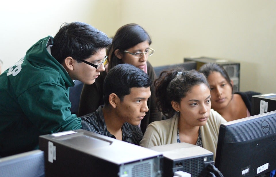 students gathered around laptop