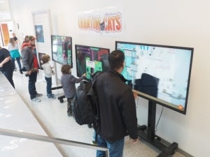 Attendees at Reunion check out the Quantum Cats game on wide-screen TVs.
