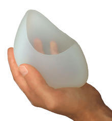 A hand holds up a Breastbowl pump.