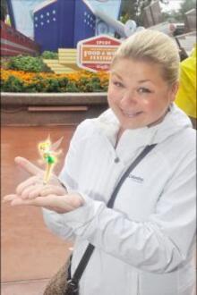 Michelle Radman poses with an image of Tinkerbell the fairy in her hands.