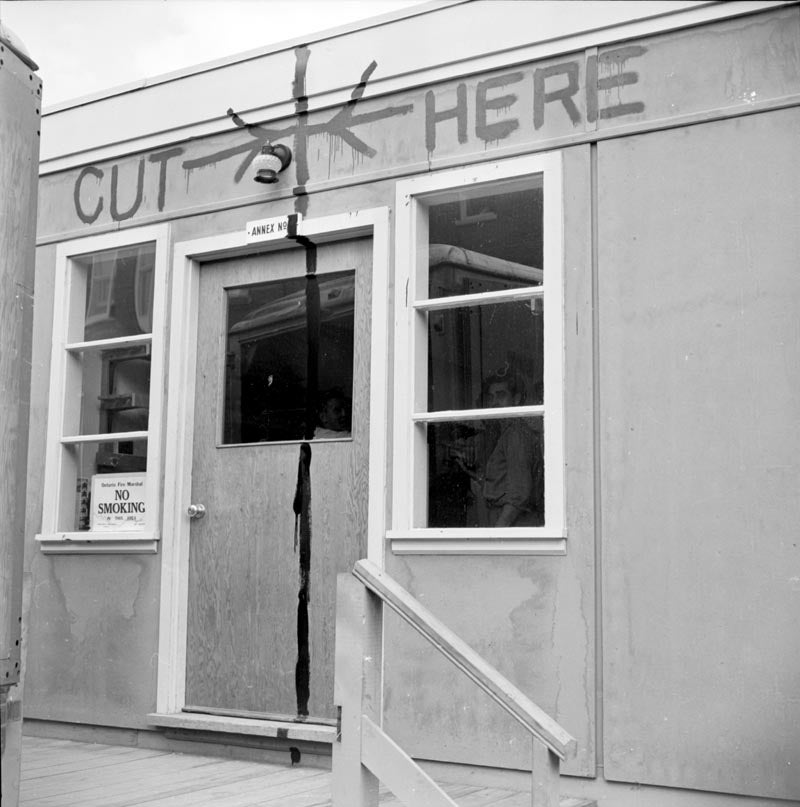 A &quot;Cut Here&quot; sign drawn on the side of one of the Annex buildings - right through a door. This was probably a joke.