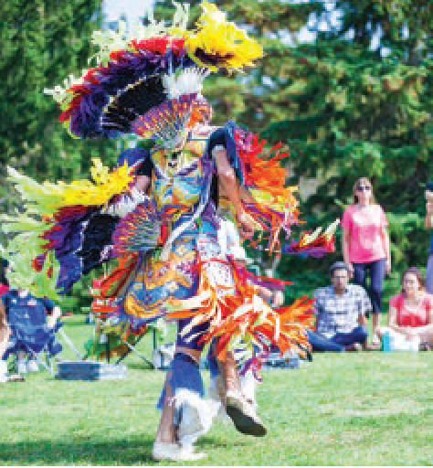 An Indigenous dancer in traditional garb at the Pow Wow.