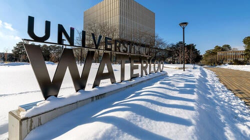The University of Waterloo sign in a winter setting.