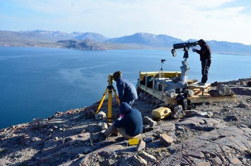 Baffinland surveyors take readings on the shore of a lake.