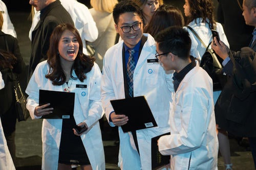 Pharmacy students react to receiving their white coats.