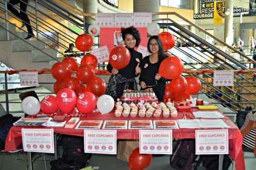 Volunteers at a booth full of balloons and United Way cupcakes.