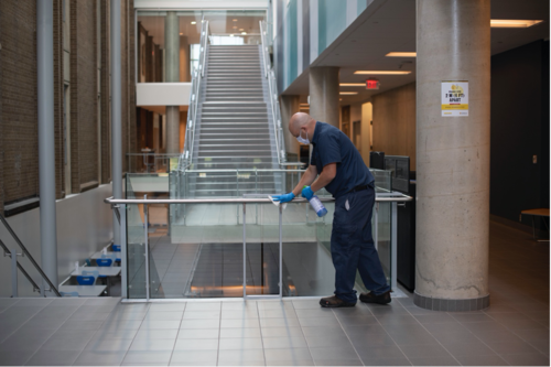 A Plant Operations volunteer wipes down a railing in the Quantum-Nano Centre.