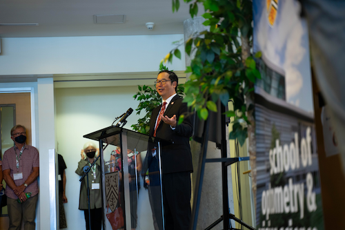 Dr. Stanley Woo speaks at a lectern during an Optometry and Vision Science announcement.