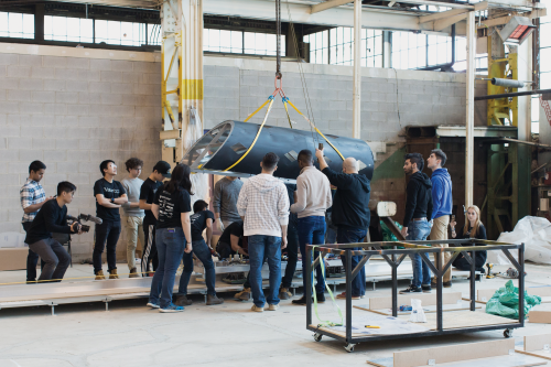 Waterloop team members move the Goose 1 prototype on a crane.