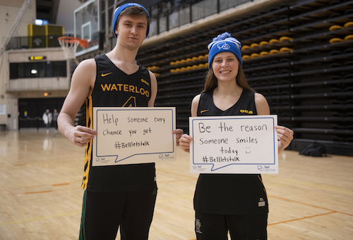 Two student-athletes hold up speech bubble placards in support of Bell Let's Talk Day.