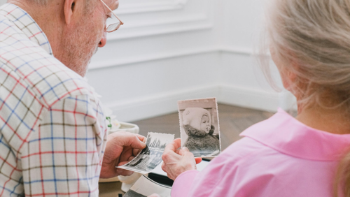 A man and woman look at old photos.