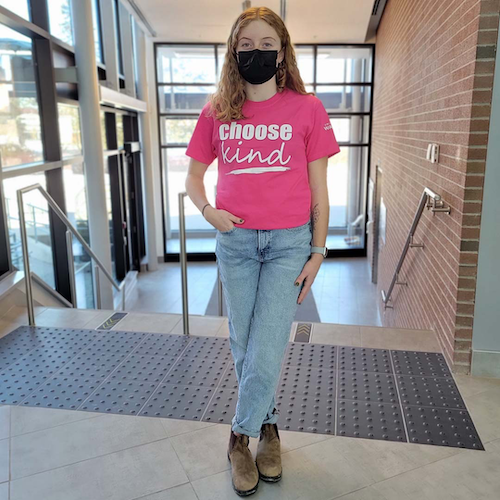 A woman wears a &quot;choose kind&quot; pink shirt.