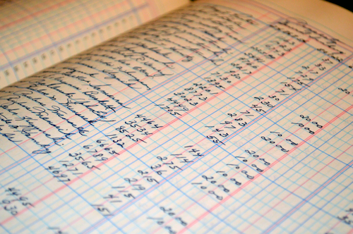 A financial ledger with sums written on it in ink.