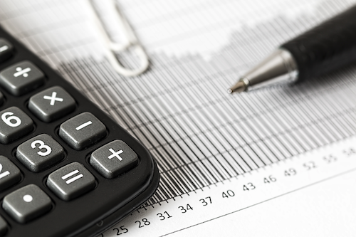 A pen and calculator atop a financial document.