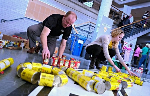 Volunteers assemble a can structure in the Student Life Centre's lower atrium.