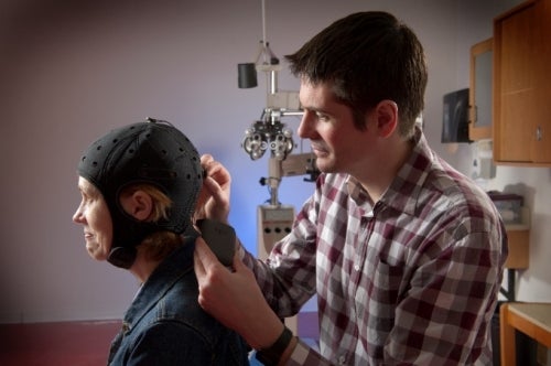 Professor Thompson adjusts a transcranial direct current stimulation device on a patient.