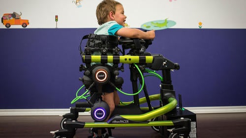 A child uses Trexo wearable robotics to walk