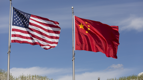 An American flag flies next to a Chinese flag.