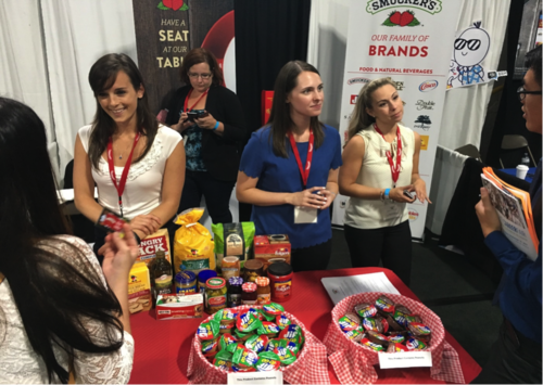 Representatives from the Smuckers jam company operate a booth at a career fair.