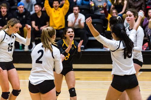 The Women's volleyball team celebrates after a victory.