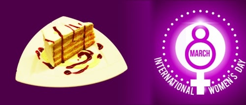 A piece of cheesecake and the International Women's Day logo.