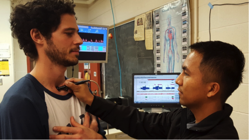 Kinesiology student Christian Delayun hooks up a monitor to a volunteer.