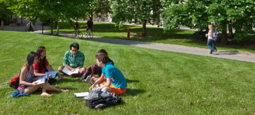 Students sit on some green space on campus.