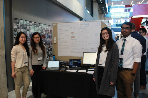 Engineering students stand with their Capstone display inside Engineering 7.