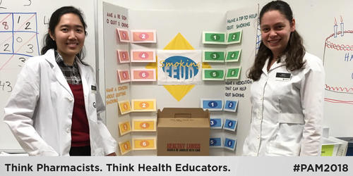 Two Waterloo Pharmacy students stand in front of a presentation board.