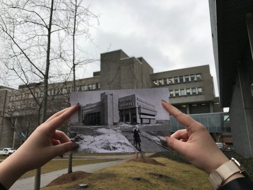 A photo of the MC building with an older photo held up for comparison.