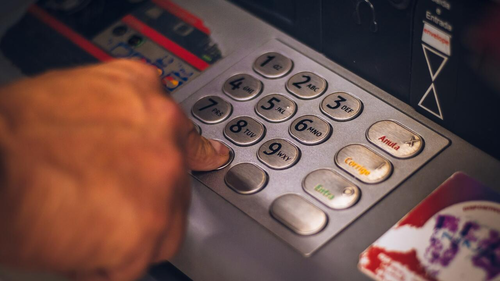 A person types on an ATM pinpad.