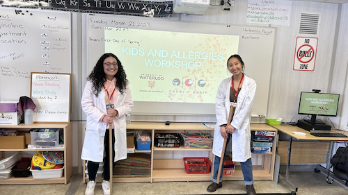 Two School of Pharmacy students speak to a classroom as part of an outreach workshop.