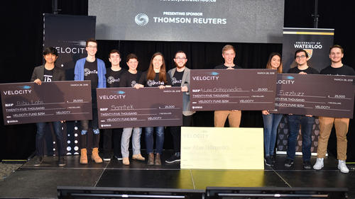 Velocity Fund winners pose on stage with their oversized cheques.