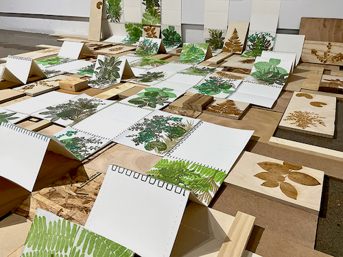 Part of the Seedlings art installation - papercraft plants arranged like a garden on a tabletop.
