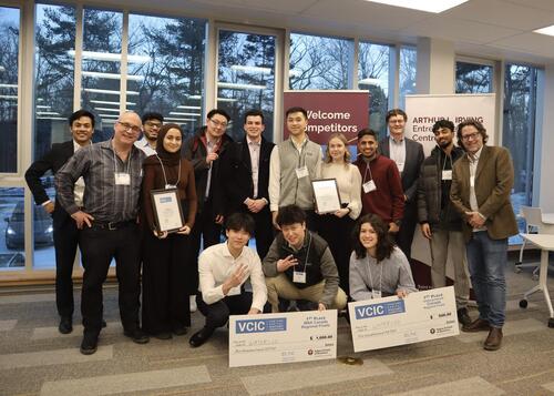 Student venture capital teams pose with their oversized cheques.