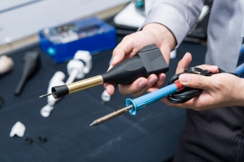 A Solder Otter soldering iron held next to a conventional soldering iron.
