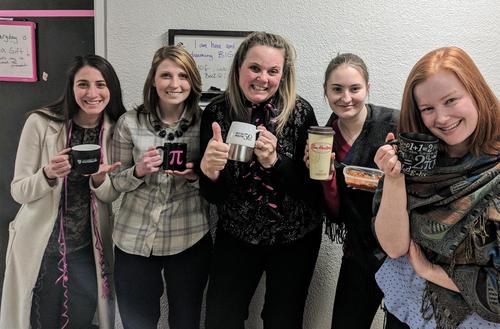 Members of the Mathematics Advancement team pose with their reusable mugs as part of the Green Office Challenge.