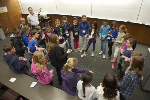 CERC researcher Phillipe Van Cappellen and a group of students who are each holding interconnected bits of string in a web.