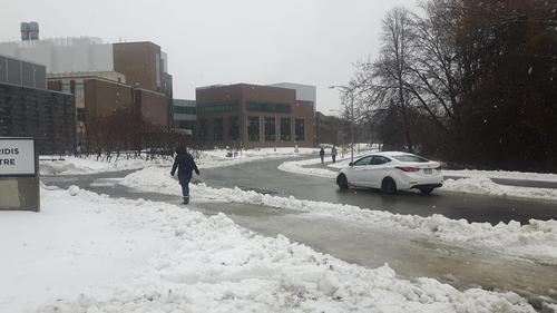 Pedestrians and cars navigate the slippery ring road outside of the Student Life Centre.
