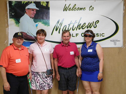 Tom Galloway, Rose Vogt, Dave Matthews and Jackie Serviss at last year's tournament in front of a poster of Burt Matthews.