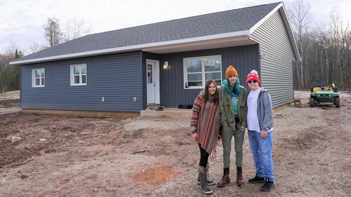 Melissa Millette (left to right) poses with two of her children, Riley and Reichal, outside their new net-zero energy house.