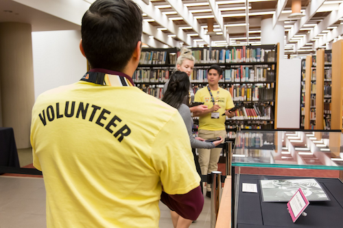 People in yellow volunteer t-shirts in a Library setting.