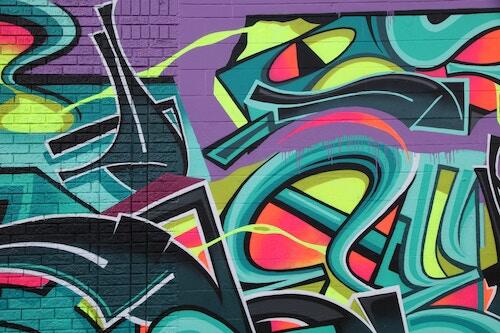 Grafitti art covers an alley wall.